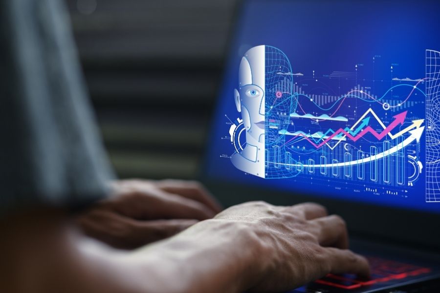 A close-up of hands typing on a laptop displaying charts and a futuristic robot head graphic representing neural networks explained.